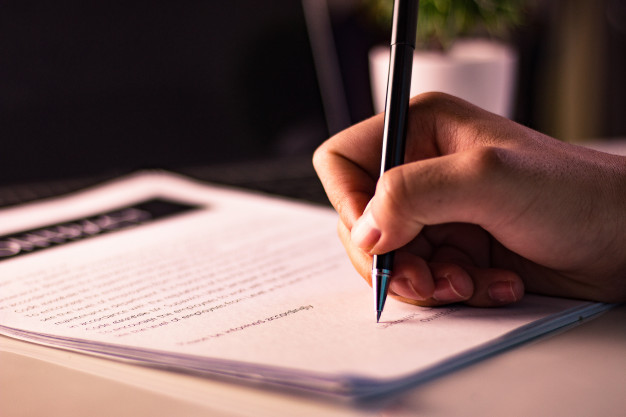 homem-negocios-assinando-um-documento-em-escritorio_29110-85